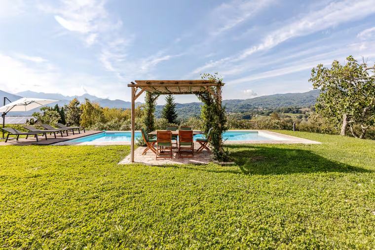Pergola sul prato con la piscina sullo sfondo