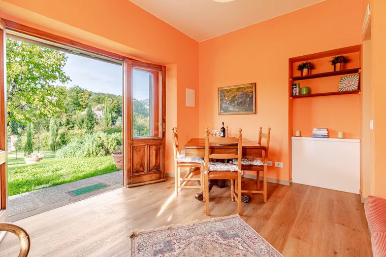 Soggiorno con zona pranzo e vetrata sul giardino